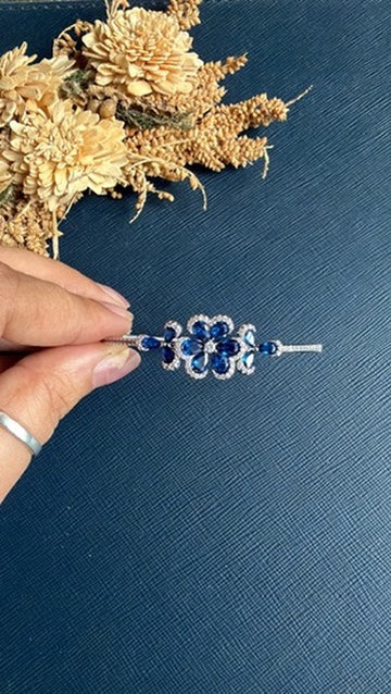 Rania royal blue diamond bracelet from another angle, showing the blue stones and silver openable band