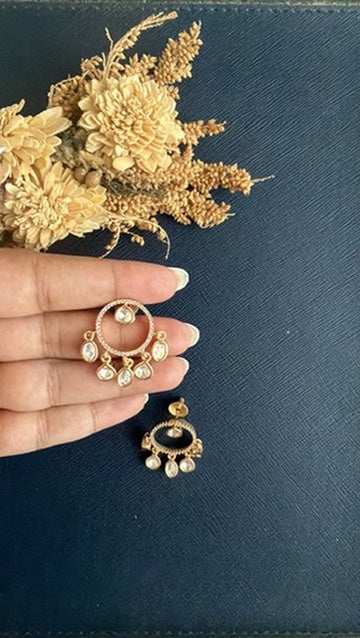Vritika Kundan stud held in hand: open circle of tiny white Kundan stones with five teardrop Kundan drops, gold-toned