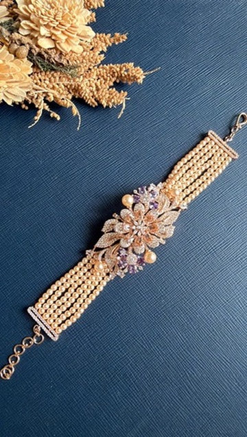 Rose gold multi-strand beaded bracelet with American diamond flower and pearl accents