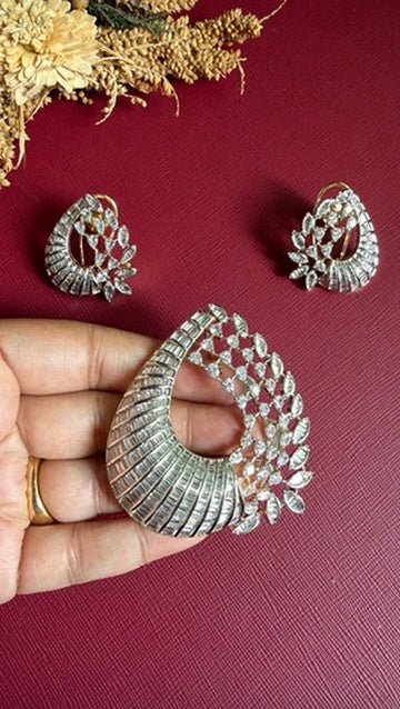 Ayesha diamond pendant held in hand to show its size, with matching American Diamond earrings