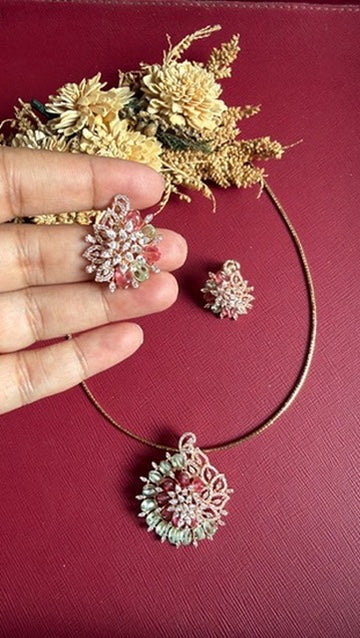 Josie floral stud earring held in hand to show its size, with the pendant on its hasli below