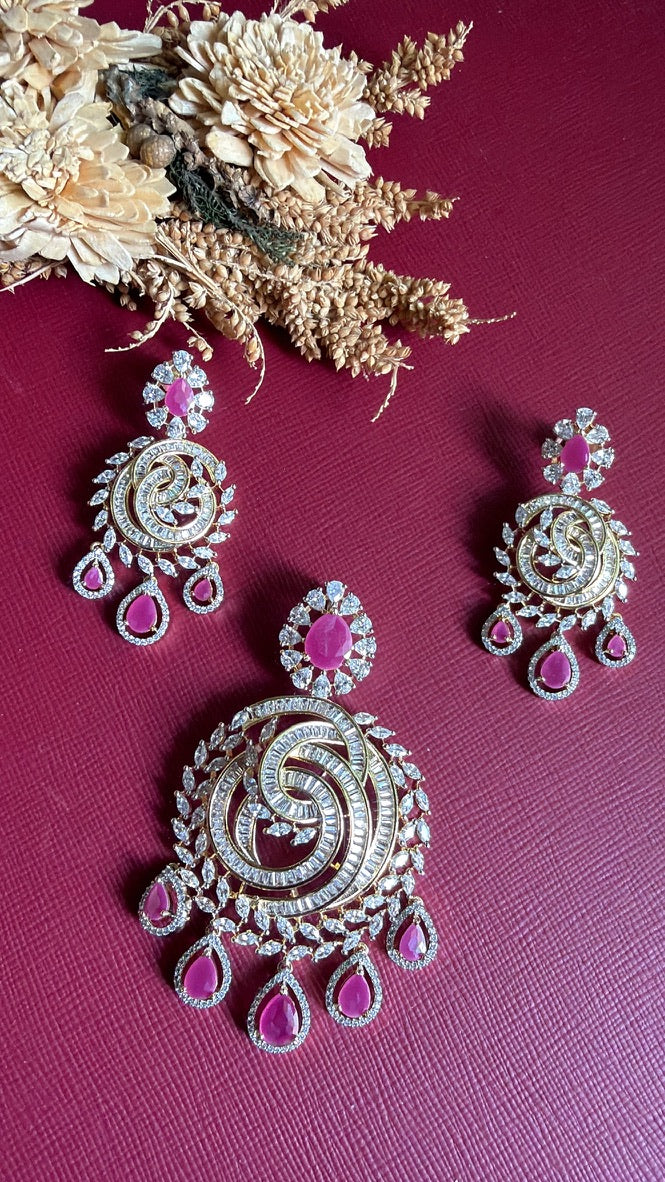 Ramya earrings held in hand beside the pendant, showing the ruby-pink pear drops