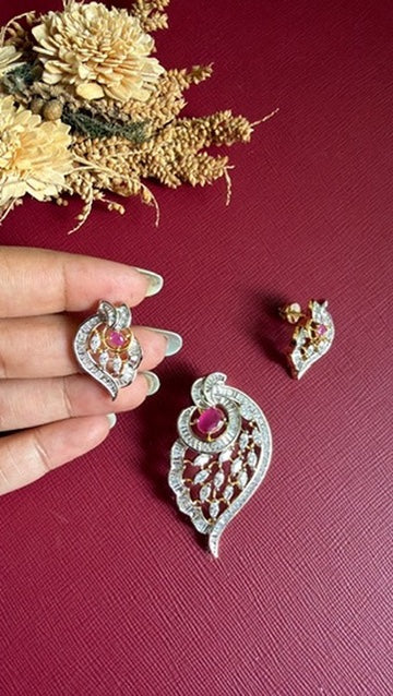 Aahana earring held in hand beside the paisley pendant, showing the open jaali work