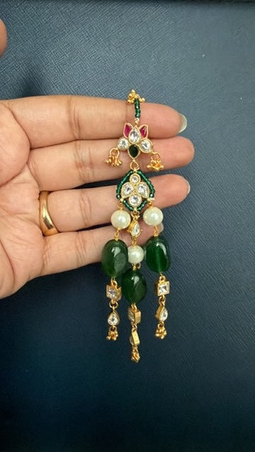 Madhuri Kundan earring held in hand – emerald green beads, pearl drops and ruby-pink Kundan top