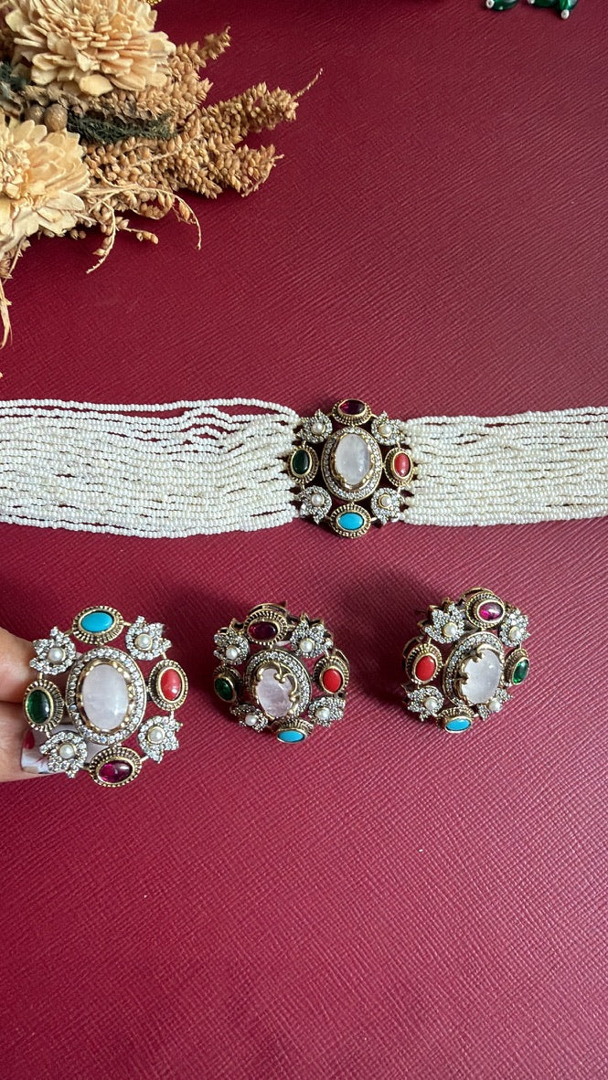 Swatika adjustable cocktail ring held on finger with matching Victorian stud earrings and choker