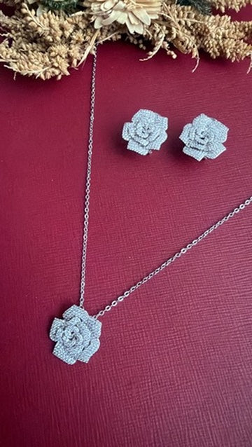 Roosy rose pendant on a fine silver-toned chain beside matching pavé rose stud earrings