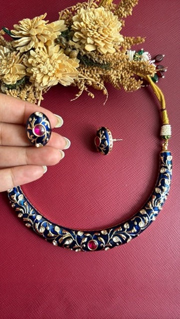 Anushree blue meena oval stud held in hand with matching hasli
