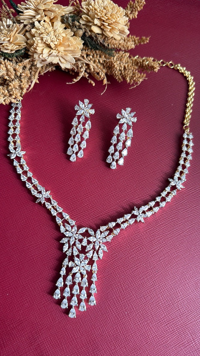 Jyosthna white American Diamond necklace with marquise flowers and a pear-drop fringe on a gold-toned setting, with matching chandelier earrings