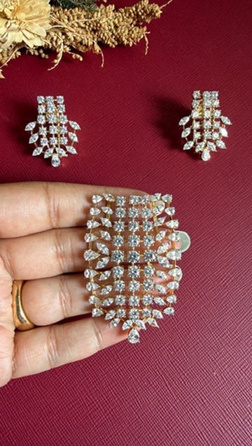 Saniya pendant held in hand to show its size, with the matching earrings above