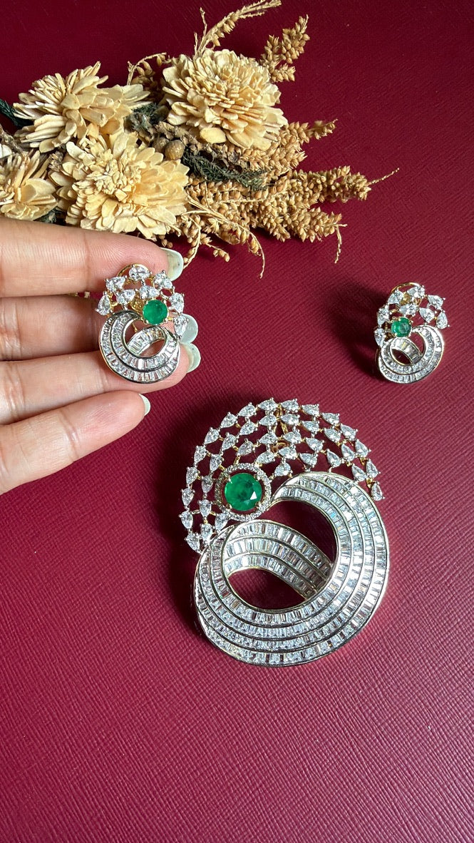 Afreen earring held in hand showing the emerald-green stone and baguette-cut American Diamond swirl