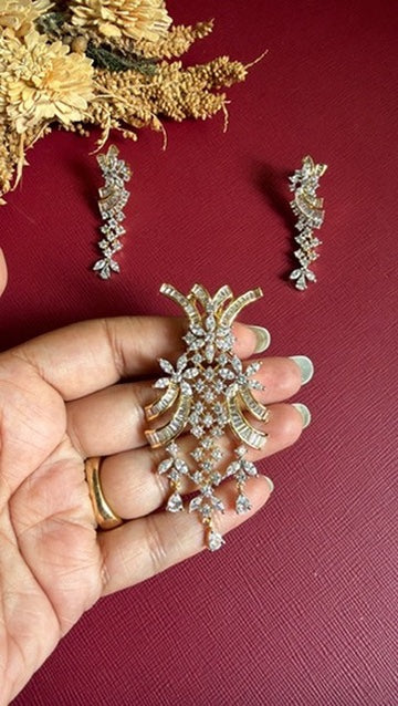 Sufiyana pendant held in hand to show its size, with the matching drop earrings above