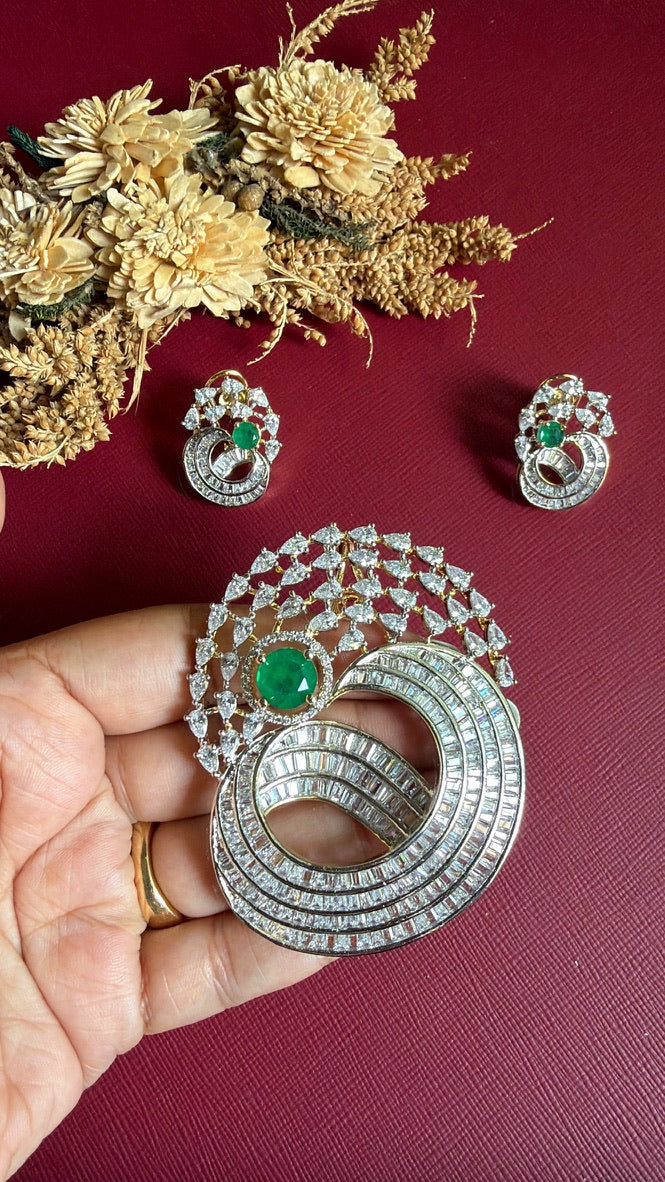 Afreen pendant held in hand to show its size, emerald-green centre and pear-shaped American Diamonds