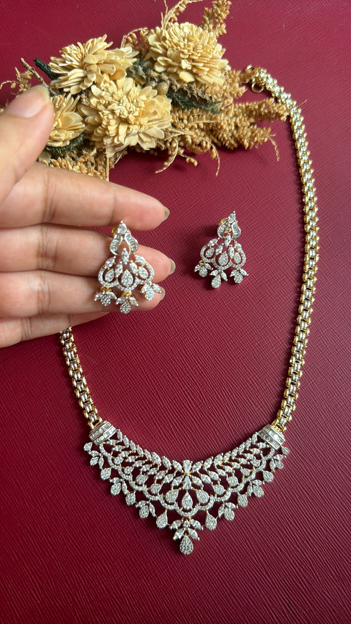 Khristy American Diamond chandelier earring held in hand with matching necklace