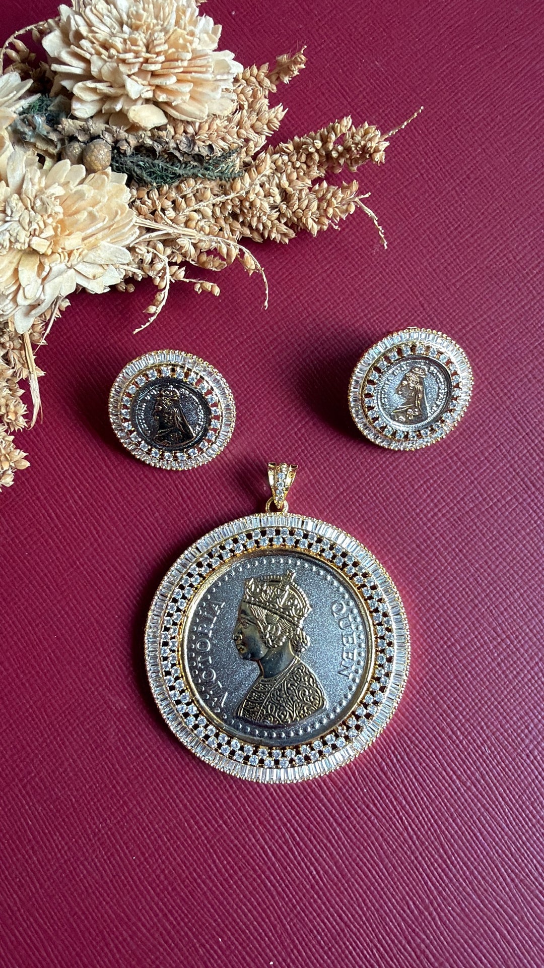 Ginni dual-tone coin pendant and coin stud earrings flat lay