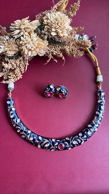 Anushree blue meena hasli with gold-toned floral vine and ruby-pink centre stone