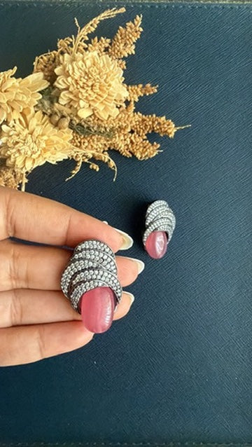 Pink doublet stone Victorian stud held in hand to show its 1.25-inch size, with the second stud beside it