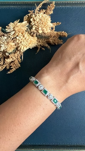 Rubina Diamond Tennis Bracelet worn on the wrist – emerald-green stones and American Diamond halos in silver