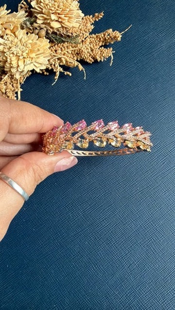 Close-up of the pastel pink and yellow oval stones on the Hania gold-tone bracelet