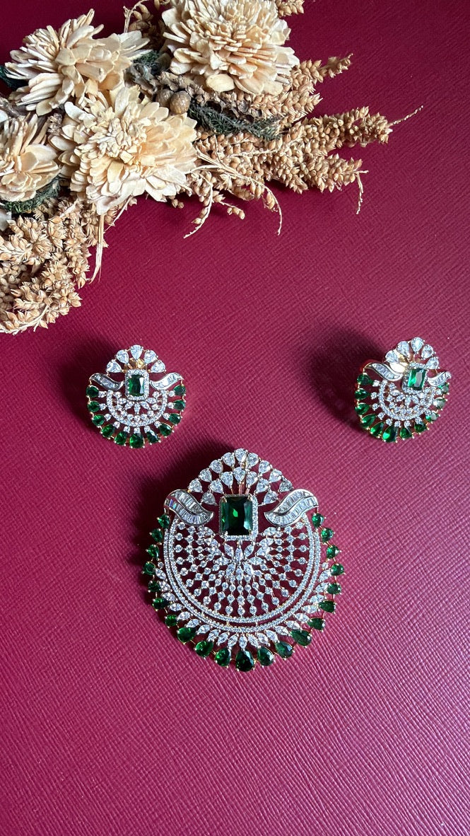 Rushika Green pendant set: cushion-cut emerald-green coloured centre stone, green pear-drop border and white American Diamond on a gold-toned setting, with matching earrings