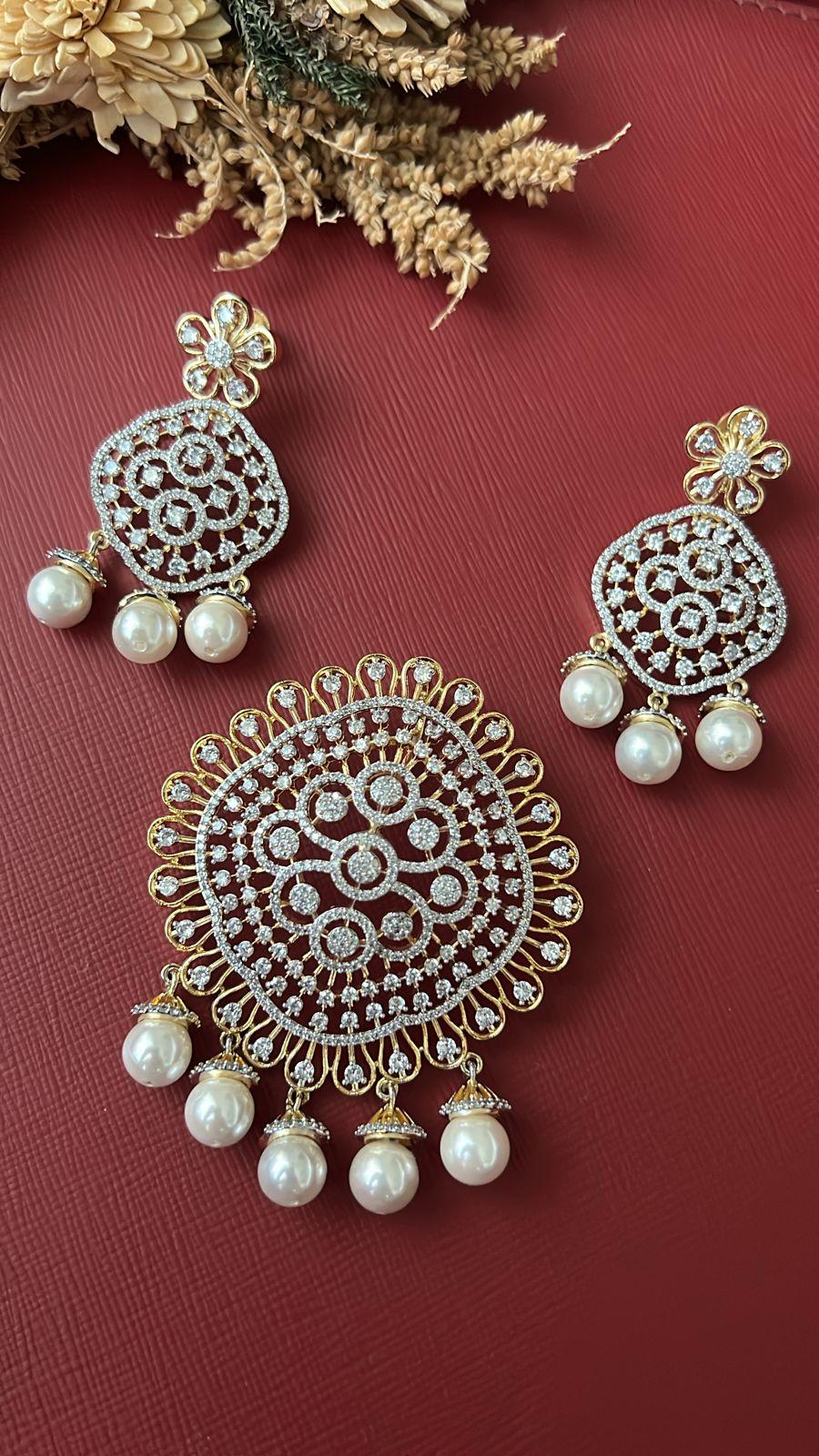 Pearl fusion earring held in hand showing size, gold-tone with CZ stones